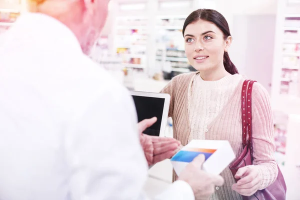 Attractive blue-eyed woman listening to a clever druggist — Stock Photo, Image