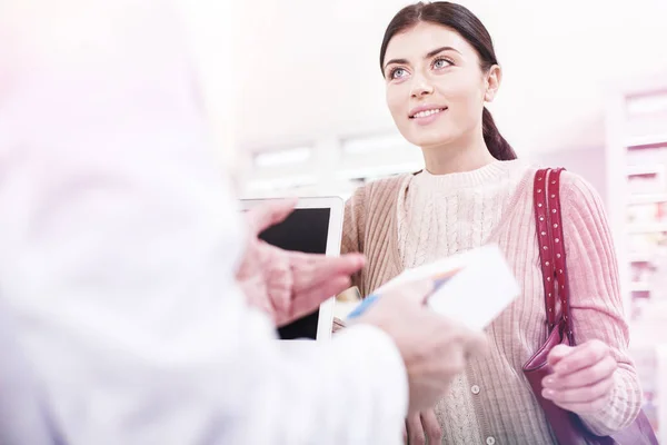 Pharmacien utile vendant un remède à un client en attente — Photo