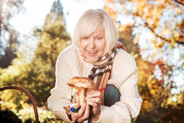 Весёлая пожилая женщина находит гриб — стоковое фото
