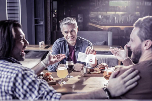 Persona masculina encantada positiva demostrando servilleta con notas — Foto de Stock