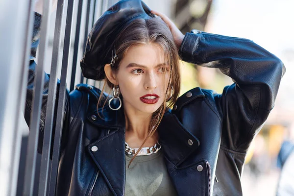 Trendiges schlankes Fotomodel mit stylischer Jacke und Mütze posiert — Stockfoto