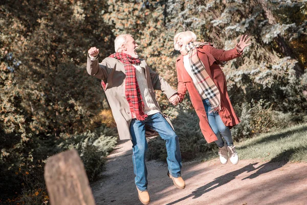 Fröhlich entzücktes Senioren-Paar springt gemeinsam auf — Stockfoto