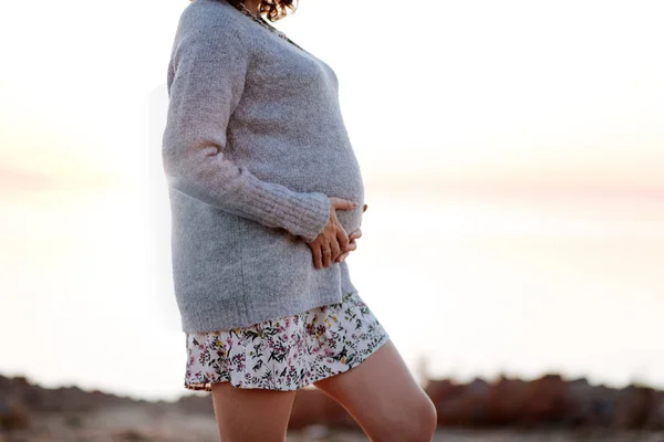 Donna incinta che indossa maglione mentre cammina all'aperto — Foto Stock