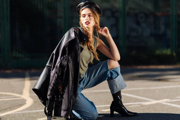 Skinny model wearing leather beret walking while shooting — Stock Photo, Image