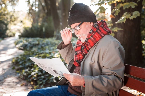 Agradable anciano sosteniendo un periódico matutino — Foto de Stock