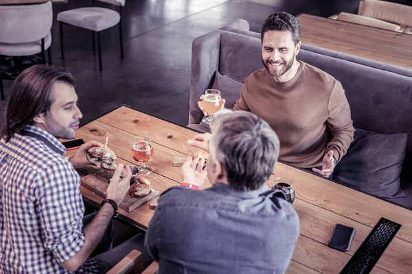 Kind brunette male going to drink beer