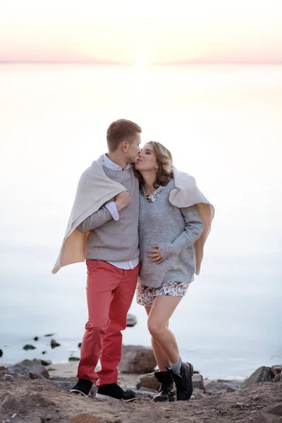 Familie gewikkeld in een plaid wandelen bij de zonsondergang — Stockfoto