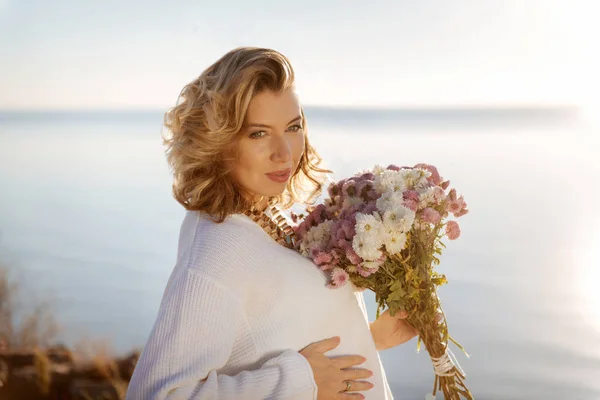 Donna incinta felice che tiene un mazzo di fiori autunnali — Foto Stock