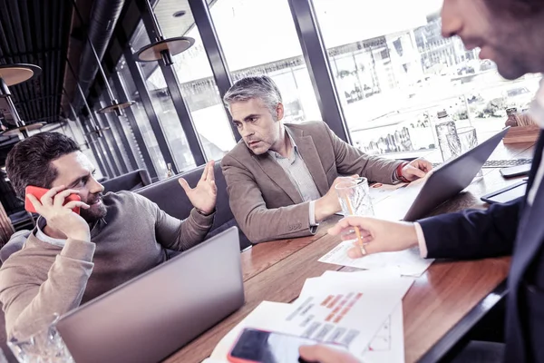 Hombre atento de pelo gris escuchando a sus compañeros — Foto de Stock