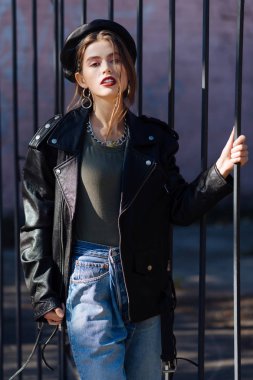 Yüksek belli kot pantolon ve siyah deri ceket giymiş güzel model