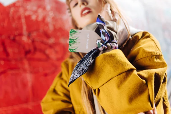 Unga berömda fotomodell främja halsduk samtidigt bär den på hennes hand — Stockfoto