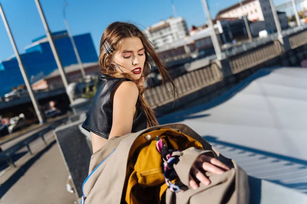 Mulher elegante com maquiagem agradável em pé na ponte desfrutando do sol — Fotografia de Stock