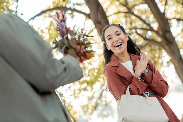 Surprised young female looking at nice bouquet — Stock Photo, Image