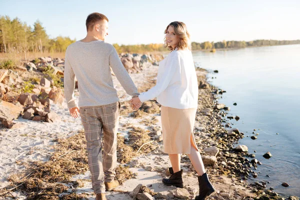 Jong gezin hebben een romantische wandeling in de buurt van het water — Stockfoto