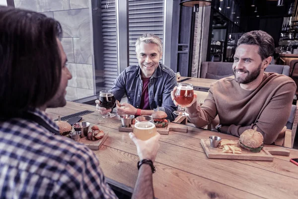 Machos amistosos sentados en la cafetería durante el descanso —  Fotos de Stock