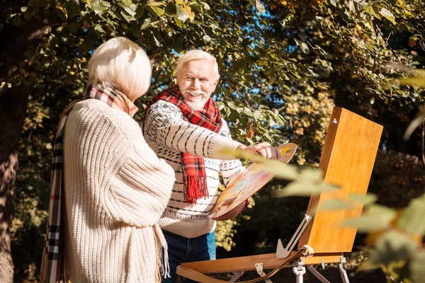 Joyful senior man painting a beautiful portrait — Stock Photo, Image