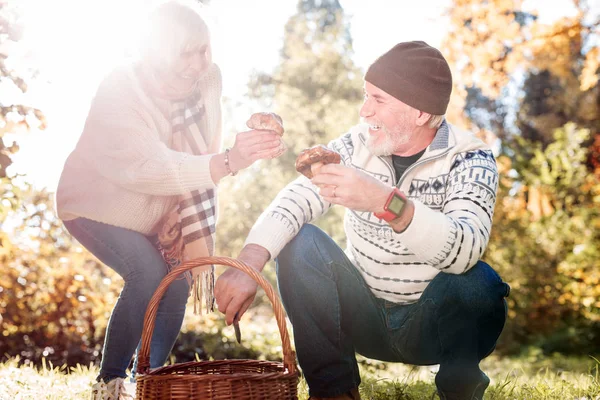 Positiv gealterte Menschen legen Pilze in den Korb — Stockfoto