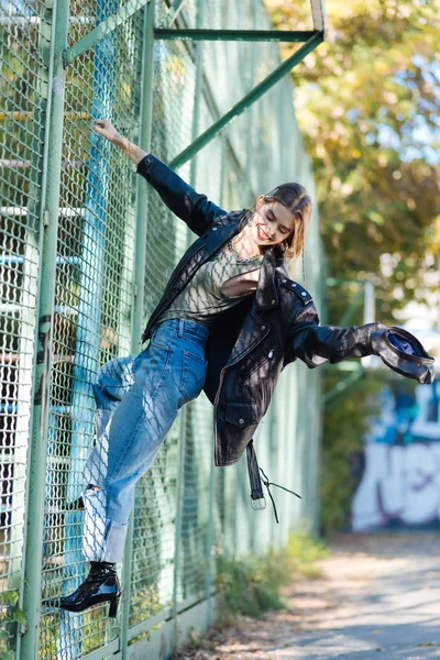 Módní hubená model na stadionu při pózování pro fotografa — Stock fotografie