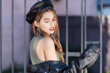 Ceketini çıkar. Sokakta fotoğraflar için poz kapalı deri ceketi alarak büyüleyici genç foto model