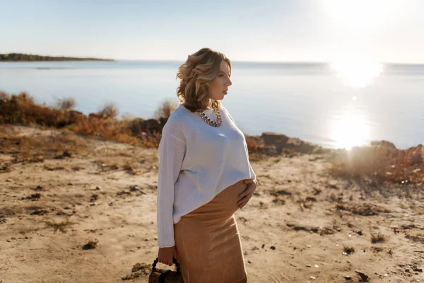 임신한 여자 맑은 날씨 동안 강 근처 산책 — 스톡 사진