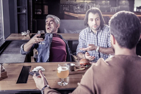 Frustrert mannlig person som stirrer på bocal med øl – stockfoto
