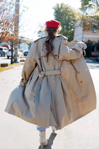 Jeune femme élégante portant un béret rouge vif et un long manteau beige — Photo