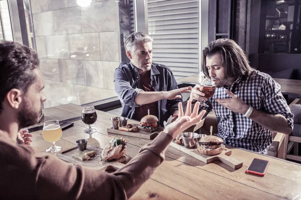 在酒吧喝烈性啤酒的集中的黑发男子 — 图库照片