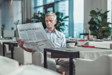 Kafede gazetede ciddi olgun adam
