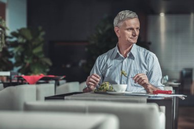 Kafede yakışıklı olgun adam yeme salata