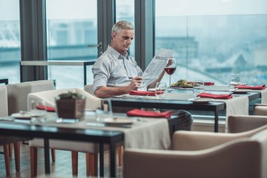 Kafede gazetede özenli kıdemli erkek