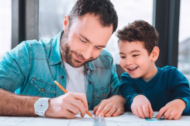 Tablo yanında oturan esmer adam