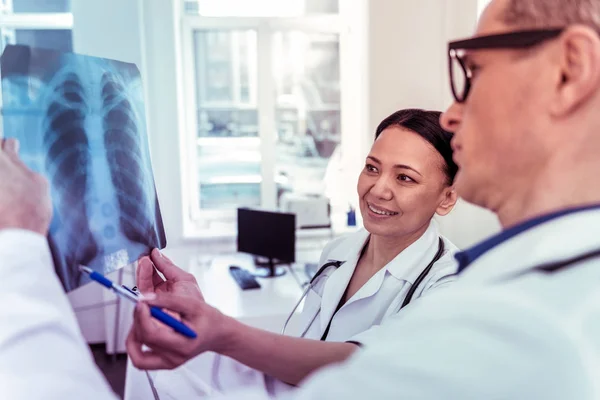 Ganska asiatiska läkare arbetar med glädje i klinik — Stockfoto