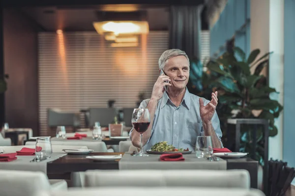 Fröhlicher älterer Mann beim Mittagessen im Restaurant — Stockfoto