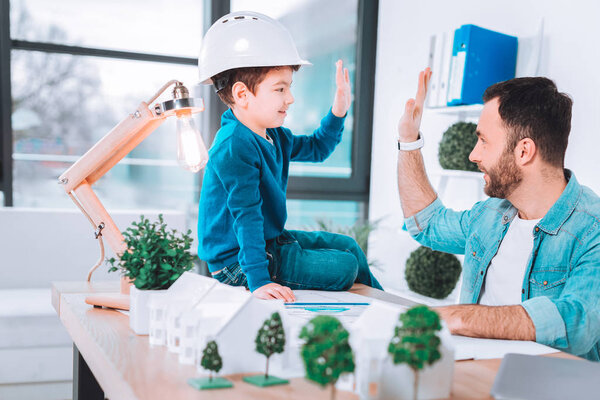 Удовлетворенные отец и сын наслаждаются результатом
