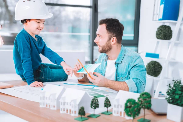 Jovem pai e filho sentados em um escritório — Fotografia de Stock