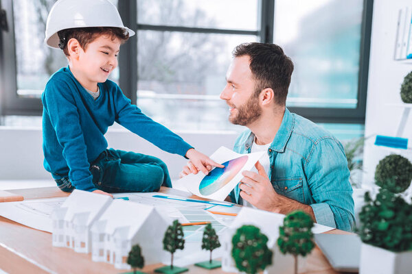 Веселый ребенок указывает на фотографию
