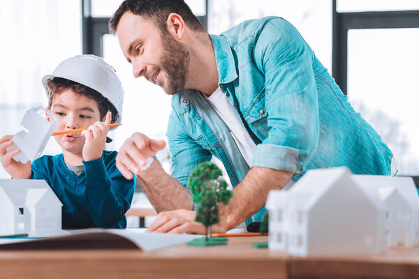 Внимательный ребенок делает фигурку из бумаги
