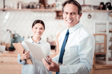 Bir dizüstü bilgisayar tutan memnun güzel iş adamı