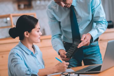 Ciddi iş adamı gösteren hesap makinesi