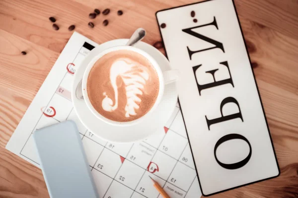 Šálek kávy stojí na kalendáře — Stock fotografie