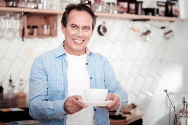 Joyful pleasant man offering you coffee — Stock Photo, Image