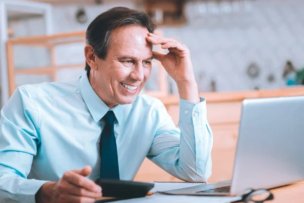 Portrait of happy male person that staring at laptop — Stock Photo, Image