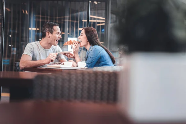 Casal alegre alimentando uns aos outros — Fotografia de Stock