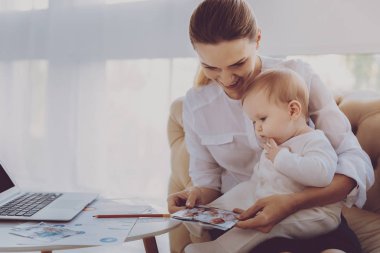 Mutlu aile kadın fotoğrafları küçük çocuğunu oturma odasında gösterilen