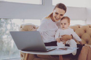 İyi kalpli genç annenin bebeği ile Laptop çizgi film izlerken