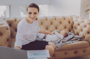 Doğum izni küçük çocuğunu uyku döşeme üzerinde genç çalışan anne