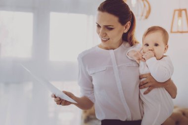 Çalışma serbest anne küçük kızın kollarında tutan belgeleri okuma