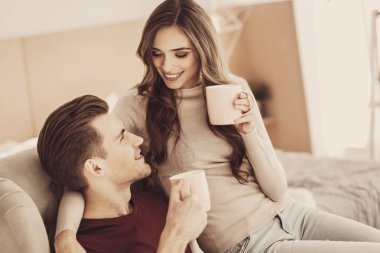 Genç sevgili çift evde sarılma sırasında birbirine bakarak