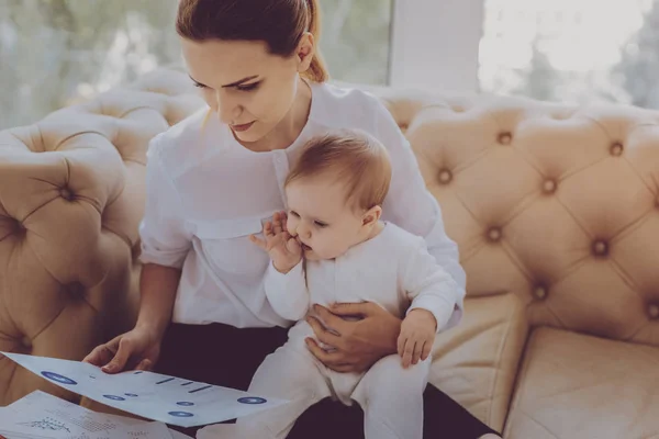 Joven madre independiente sintiéndose inspirada mientras escribe un nuevo artículo de moda — Foto de Stock