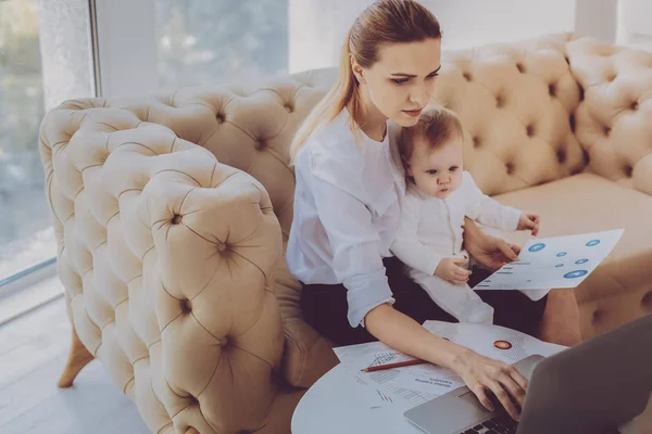 Karriär kvinna att skriva affärsbrev medan spendera tid med lilla dotter — Stockfoto